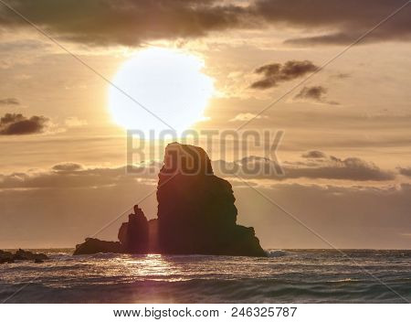 Evening Bay. Sharp Rocks, Black Rounded Boulders, Stony Beach, Sand And Dark Sky.