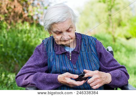 Elderly Ill Woman Holding Pulse Oxymeter On Fingertip Outdoor