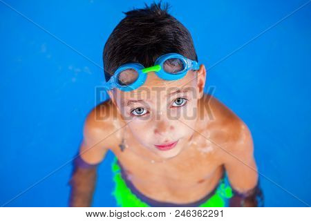 Smiling Baby Boy With Swimming Glasses In Swimming Pool.