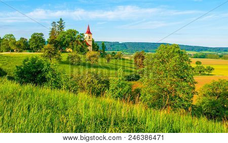 Small Church In The Middle Of Lush Green Spring Landscape On Sunny Day. St. Peter And Pauls Church A