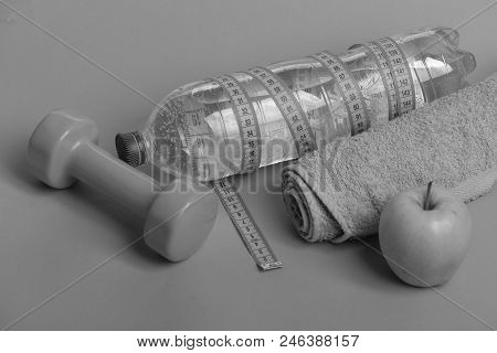 Dumbbell In Bright Green Color, Water Bottle, Measure Tape, Towel And Fruit On Green Background. Hea