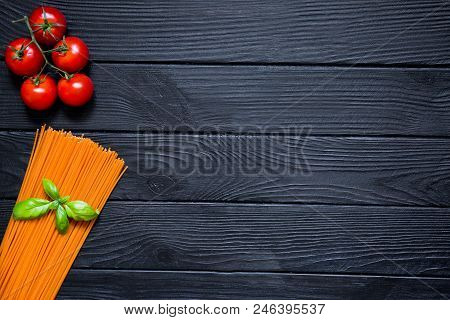 Organic Tomato Spaghetti With Fresh Cherries And Basil Leaf On Black Wooden Background. Italian Cuis