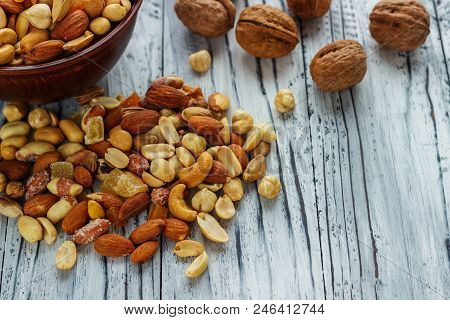 Mix Nuts In Earthenware On A Wooden Background.