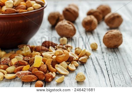 Mix Nuts In Earthenware On A Wooden Background.