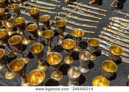 Daggers And Knives In A Steel Case And Metal Wine Cups.