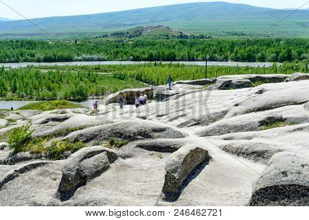 UPLISTSIKHE - MAY 5: Tourists enjoy the sunny weather and walk around the ancient rock city on 5 May 2018 in Uplistsikhe (Upliscyche), Georgia