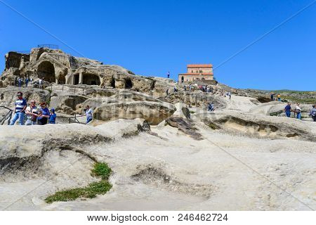 UPLISTSIKHE - MAY 5: Tourists enjoy the sunny weather and walk around the ancient rock city on 5 May 2018 in Uplistsikhe (Upliscyche), Georgia