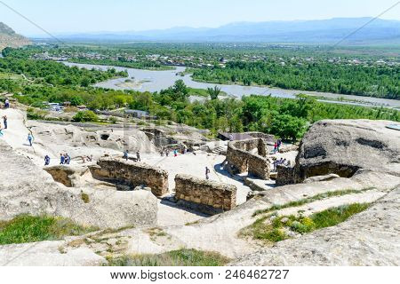 UPLISTSIKHE - MAY 5: Tourists enjoy the sunny weather and walk around the ancient rock city on 5 May 2018 in Uplistsikhe (Upliscyche), Georgia