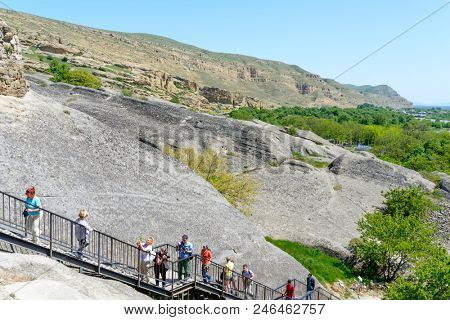 UPLISTSIKHE - MAY 5: Tourists enjoy the sunny weather and walk around the ancient rock city on 5 May 2018 in Uplistsikhe (Upliscyche), Georgia