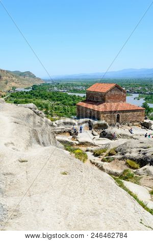 UPLISTSIKHE - MAY 5: Tourists enjoy the sunny weather and walk around the ancient rock city on 5 May 2018 in Uplistsikhe (Upliscyche), Georgia