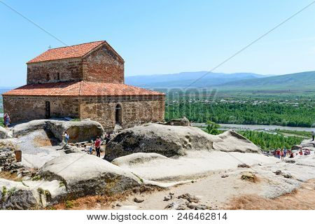 UPLISTSIKHE - MAY 5: Tourists enjoy the sunny weather and walk around the ancient rock city on 5 May 2018 in Uplistsikhe (Upliscyche), Georgia