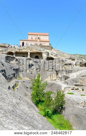 UPLISTSIKHE - MAY 5: Tourists enjoy the sunny weather and walk around the ancient rock city on 5 May 2018 in Uplistsikhe (Upliscyche), Georgia