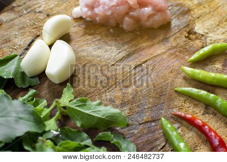 Raw Material Of Stir Fried Pork And Basil Such As Pork,basil,chilli,garlic On A Wooden Chopping Boar