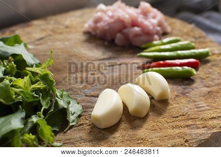 Raw Material Of Stir Fried Pork And Basil Such As Pork,basil,chilli,garlic On A Wooden Chopping Boar