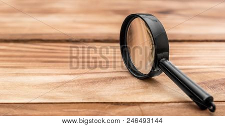 Magnifying Glass On Wooden Table. Close Up.