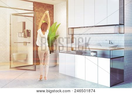 Double Sink Standing On White Countertops In A White And Brick Bathroom Interior. Shelves In The Cor