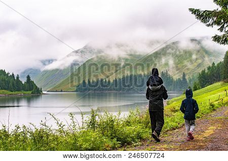 View Of A Beautlful Lake Talla In Scottish Borders With Green Hills Covered By Thick Rainy Clouds.