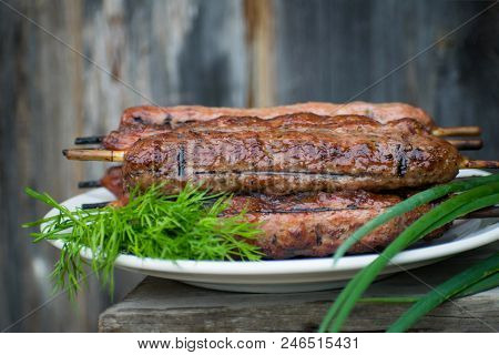 Lulya Kebab From Meat On A White Plate And Wooden Board