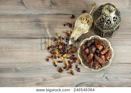 Orintal Lamp Latern, Raisins And Dates On Wooden Background