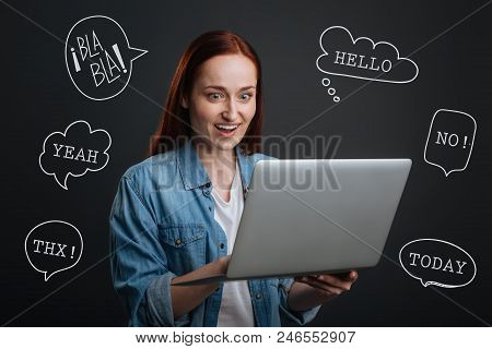 Happy Blogger. Cheerful Popular Blogger Standing With A Modern Laptop In Her Hands And Feeling Excit
