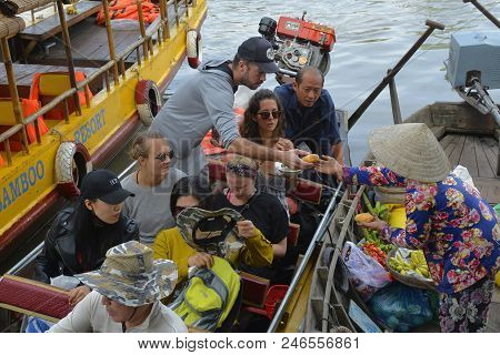 Phong Dien, Vietnam - December 31st 2017. A Tourist On A Boat Tour Considers Buying Fruit From A Ven