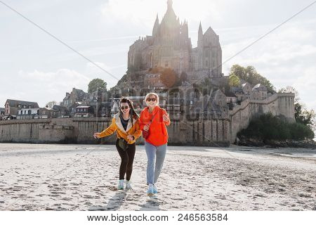 Happy Friends Running On Beach Near Saint Michaels Mount, Normandy, France
