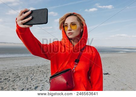 Beautiful Girl In Red Hoodie Taking Selfie On Beach, Saint Michaels Mount, France