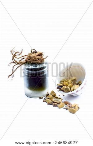 Green Colored Dry Fruit Essence Of Green Cardamom Or Elaichi Isolated On White In Transparent Bottle