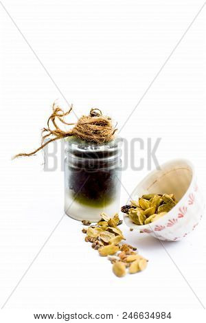 Green Colored Dry Fruit Essence Of Green Cardamom Or Elaichi Isolated On White In Transparent Bottle