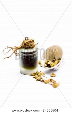 Green Colored Dry Fruit Essence Of Green Cardamom Or Elaichi Isolated On White In Transparent Bottle