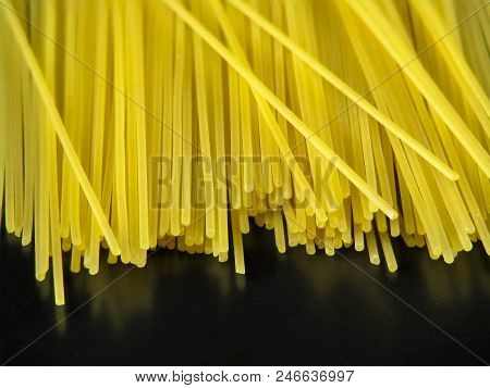 Uncooked Yellow Italian Pasta Spaghetti On Black Background Close-up