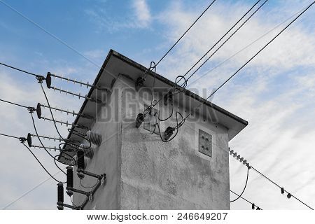 A Abstract Gray Transformer House Distributes The Power Lines Against A Blue Cloudy Sky
