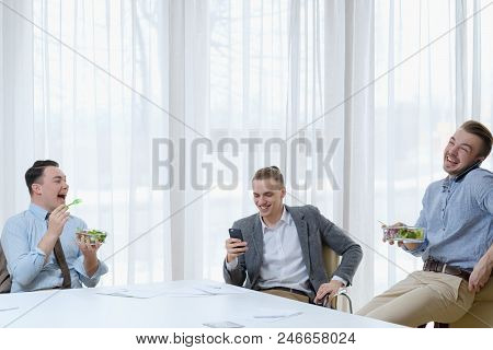 Relaxed Office Atmosphere. Communication And Comradery At Work. Business Men Laughing And Talking At