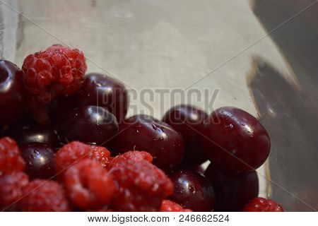 Fresh Fruits Of Cherries And Raspberries In Glass.