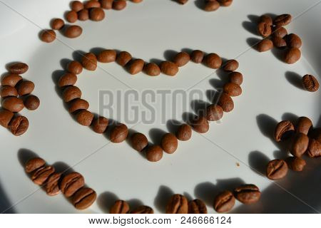 On A White Glass Plate Lie Brown Coffee Beans Laid Out In The Form Of A Heart Of Coffee Beans Love