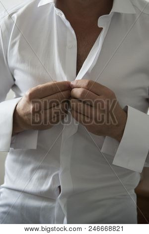 A Groom Putting On Cuff-links As He Gets Dressed In Formal Wear. Groom's Suit