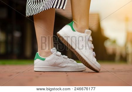 Female Legs In Street Sneakers Nature Sun Skyon Blur Background Beauty Fashion
