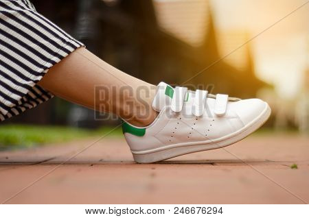 Female Legs In Street Sneakers Nature Sun Skyon Blur Background Beauty Fashion