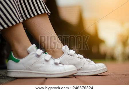 Female Legs In Street Sneakers Nature Sun Skyon Blur Background Beauty Fashion