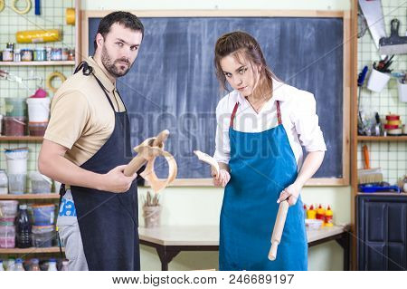 Two Caucasian Ceramists Posing With Broken Jar Bites After Squarrel And Crashed Clay Bowlin Front Of