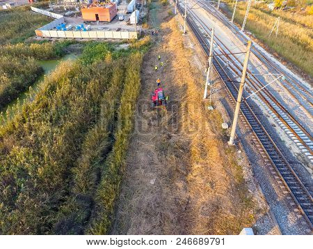 The Bulldozer Clears The Space Along The Railway Tracks. Raking Of Reeds By Bulldozer.