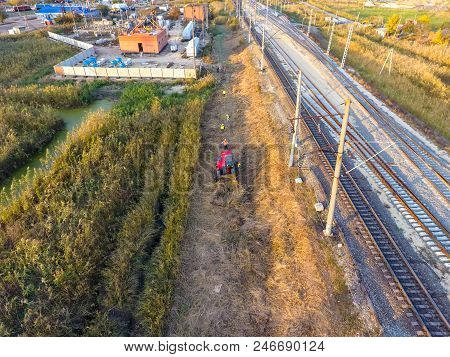 The Bulldozer Clears The Space Along The Railway Tracks. Raking Of Reeds By Bulldozer.