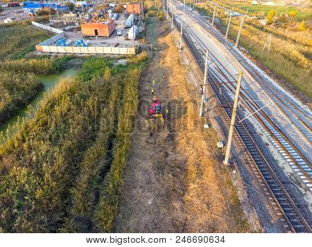 The Bulldozer Clears The Space Along The Railway Tracks. Raking Of Reeds By Bulldozer.