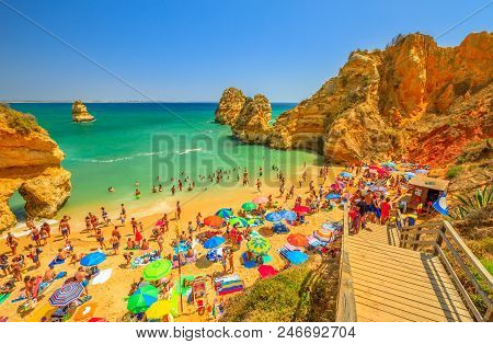 Lagos, Portugal - August 21, 2017: Crowd Of People Sunbathing And Enjoying Under Colorful Umbrellas 