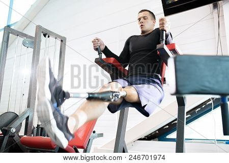 Low Angle Portrait Of Handsome Muscular Man With Prosthetic Leg Doing Pull Ups While Working Out In 