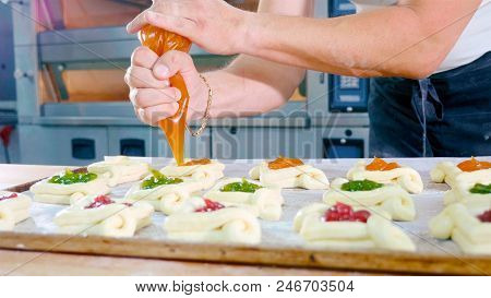 Professional Baker Adding Jam On Top Of Sweet Baking Before Put It Into Oven At Commercial Kitchen, 