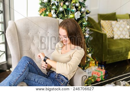 Girlfriend Get Smartwatch From Boyfriend As Present For New Year, Smiling Lady Sitting In Chair Near