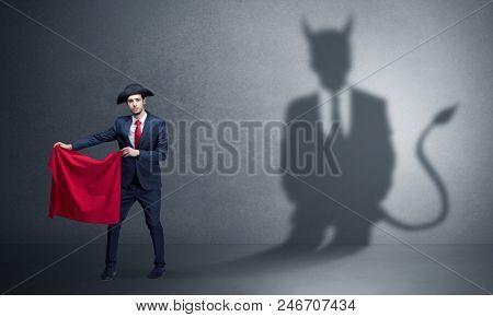 Businessman standing with red cloth in his hand and devil shadow on the background