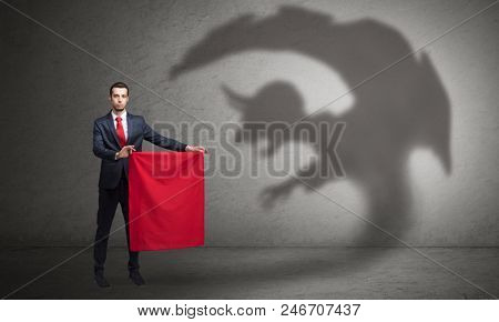 Businessman standing with red cloth in his hand and imp shadow on the background