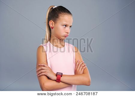 Offended Kid. Cute Teenage Girl Pouting And Crossing Her Arms Across Her Chest While Looking Away Fr